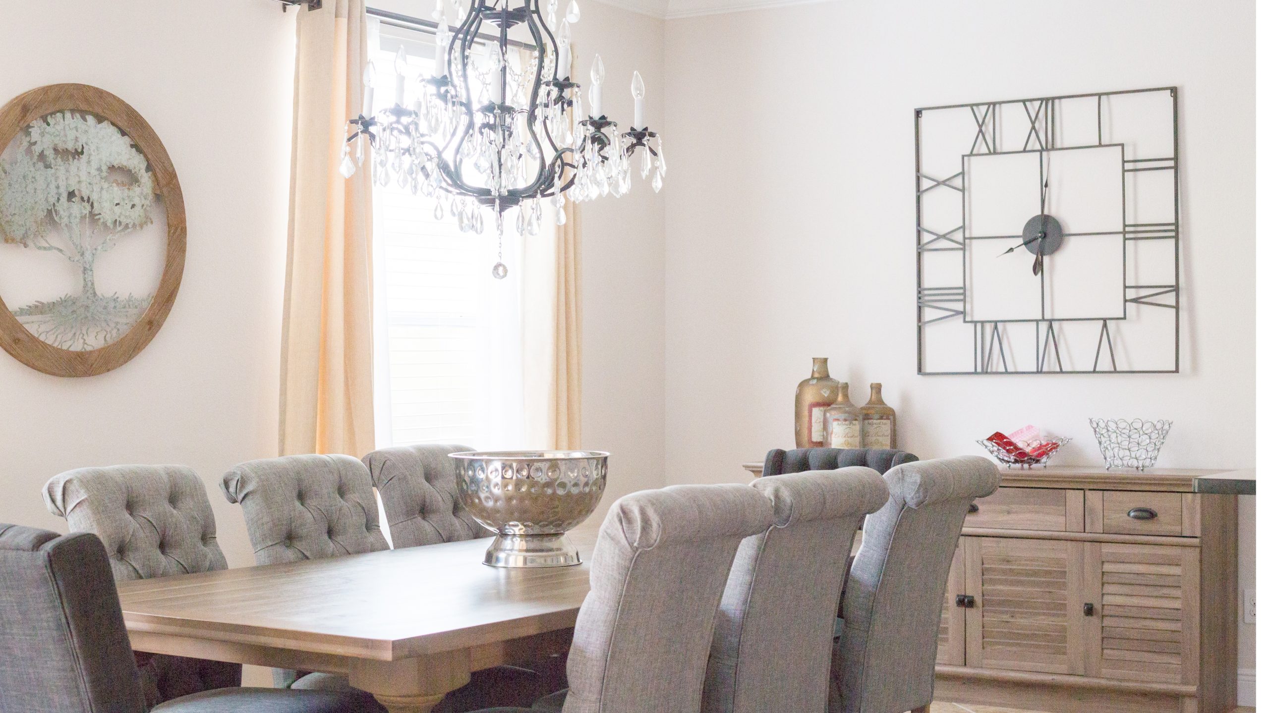Elegant Dining Room with Modern Decor Bright dining room with a wooden table, tufted chairs, and modern wall clock.