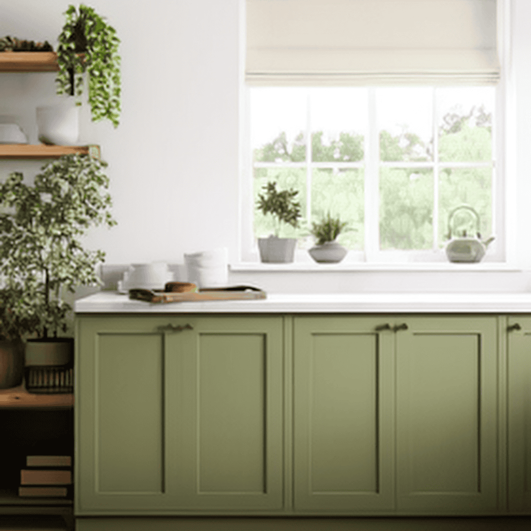Clean Green Kitchen Cabinet with Plants Bright kitchen with green cabinets and potted plants by window.